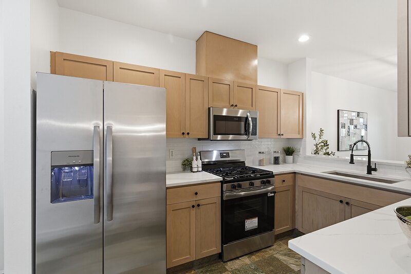 Stainless steel refrigerator and gas range in the kitchen
