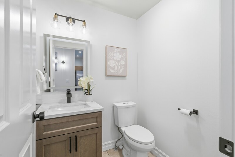 Powder room with a new vanity and lit mirror